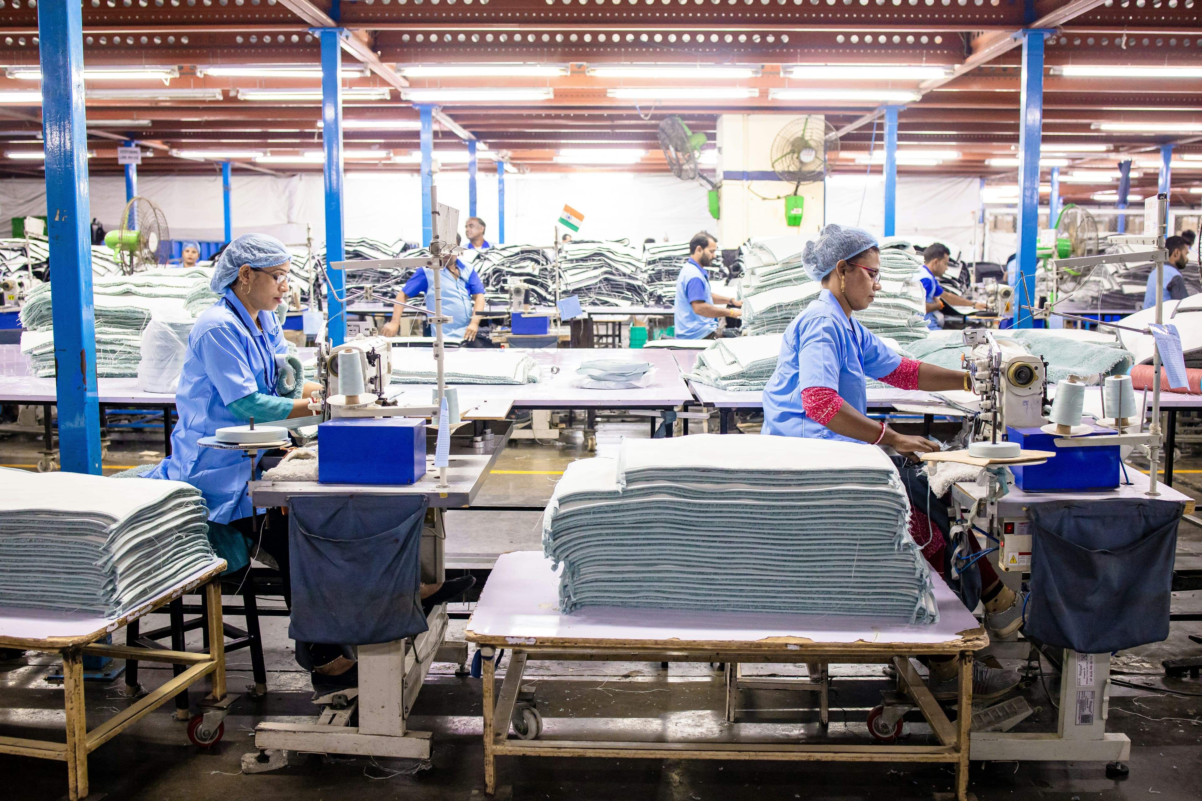 Operario revisando producción en una planta textil.